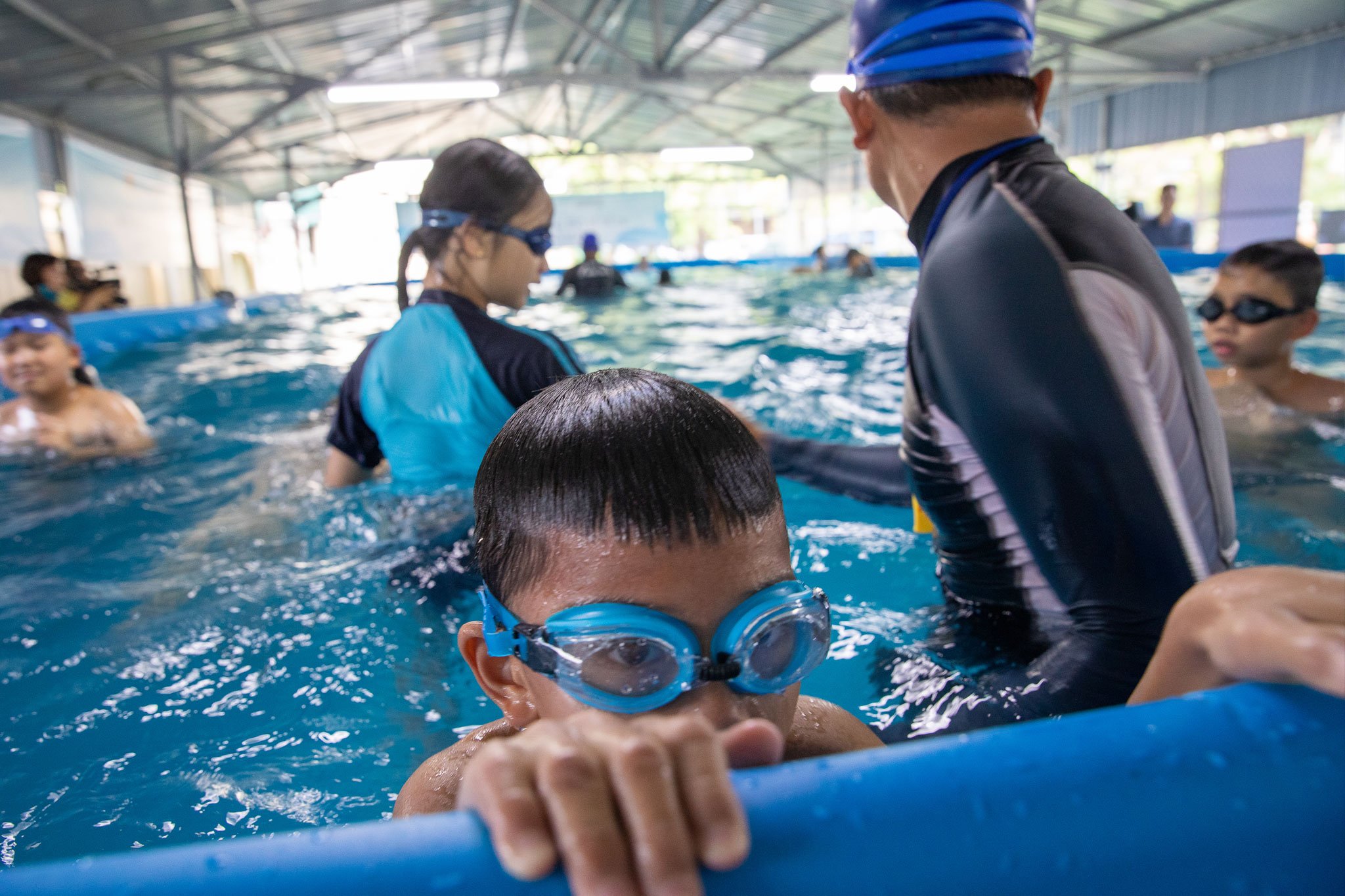 Kids swimming with a Coach in swimming pool