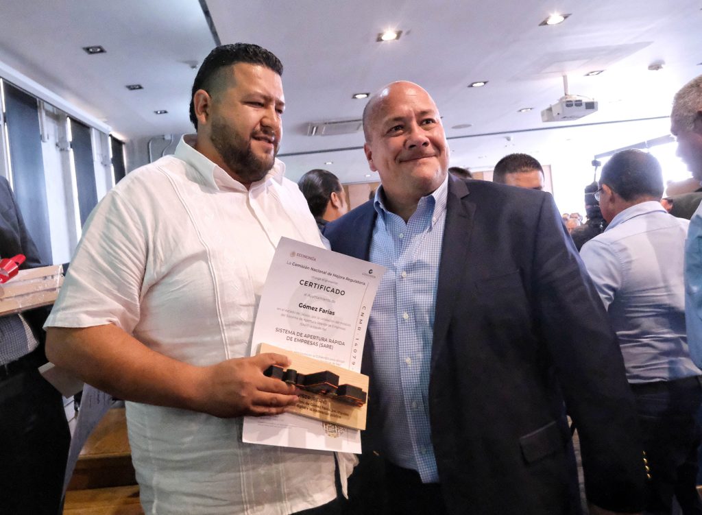 Two men posing with a certificate