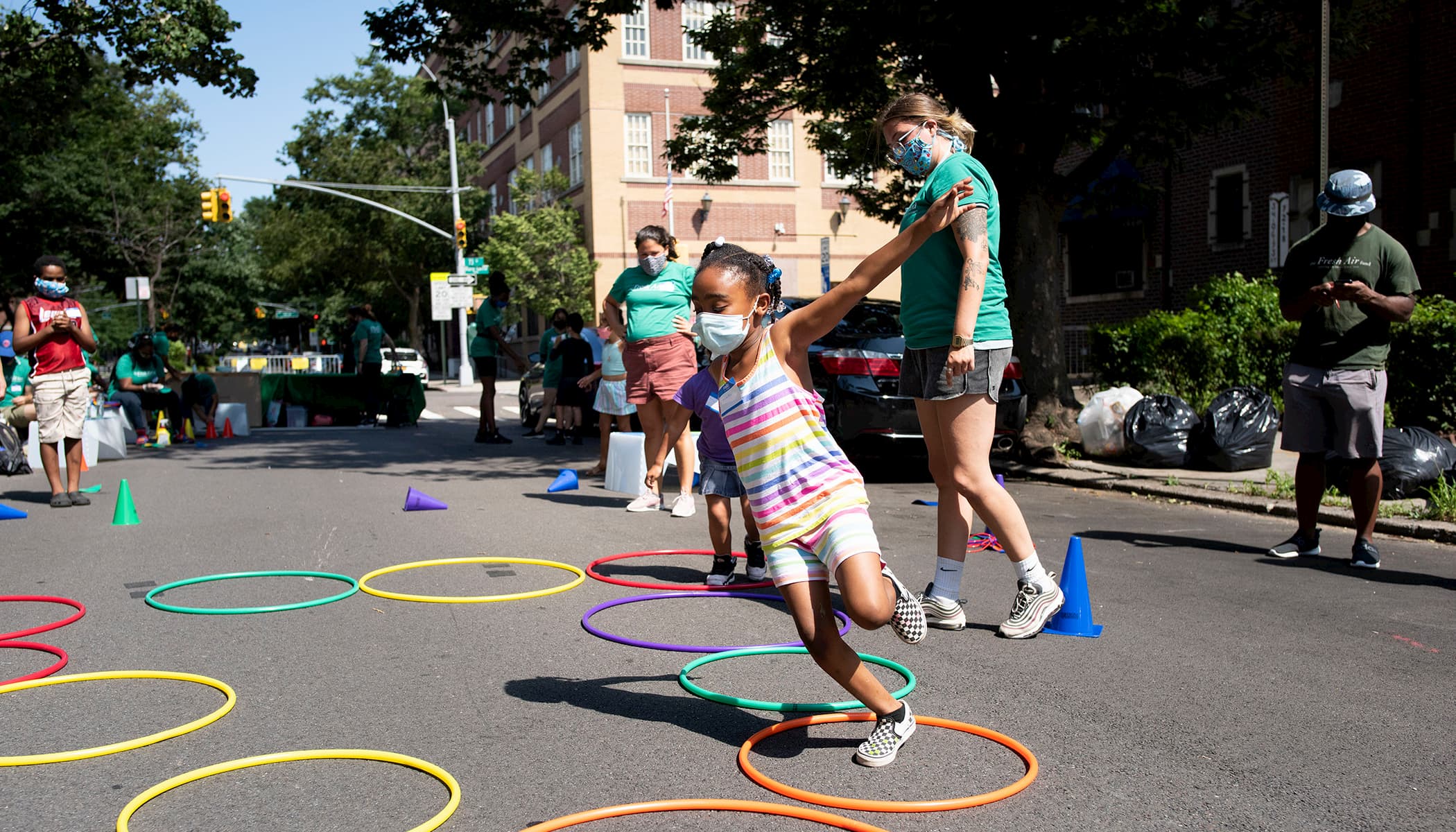 A young girl plays outside in the Jackson Heights neighborhood in Queens, New York during Fresh Air Fund Summer Space, an outdoor summer program for youth supported by Bloomberg Philanthropies, Ford Foundation, and the JPB Foundation.